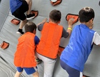 Gemeinsam stark! – Beim Hindernisparcours zählte nicht nur Kraft, sondern auch Teamgeist: Hier hilft ein Mädchen ihren Mitschülern beim Klettern.