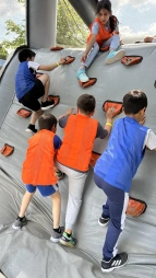 Gemeinsam stark! – Beim Hindernisparcours zählte nicht nur Kraft, sondern auch Teamgeist: Hier hilft ein Mädchen ihren Mitschülern beim Klettern.