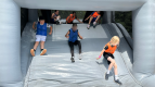 Geschafft! – Mit voller Energie rutschen die Kinder ins Ziel und feiern ihren Teamerfolg auf der aufblasbaren Riesenrutsche.